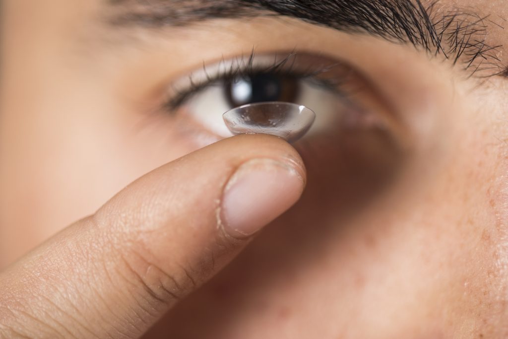Pessoa colocando a lente de contato para miopia  a hipermetropia nos olhos