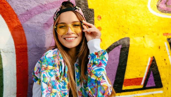 Menina com roupa colorida em uma parede de grafite